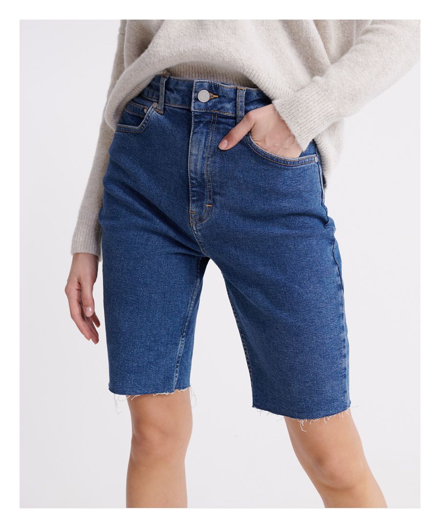 Superdry women's Kari long line shorts. These shorts feature a five pocket design including a coin pocket, an unfinished hem, a button and zip fastening and belt loops. Complete with a Superdry logo patch on the back of the waistband.
