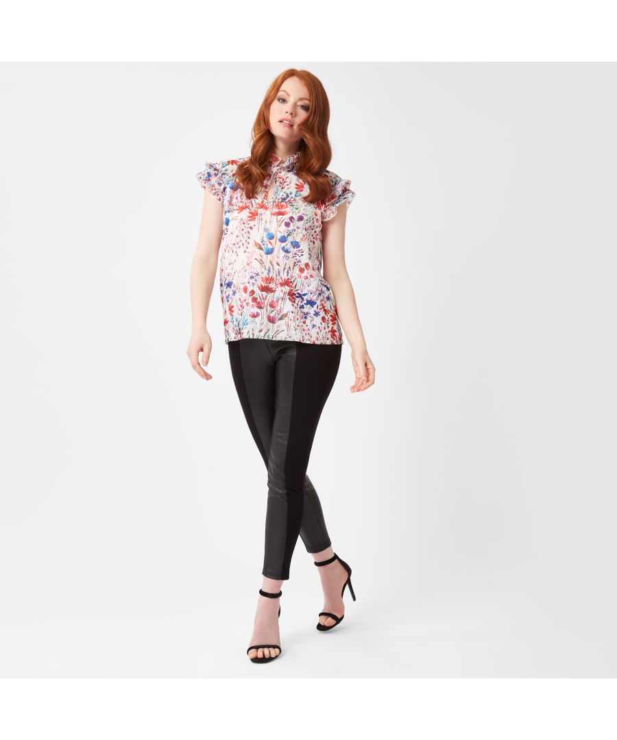 Featuring a sleeveless double ruffle detail to the shoulder, key hole opening with a concealed button and ruffle high neck, this poppy floral blouse is feminine and perfect for wearing during the summer months with wide leg jeans and flats