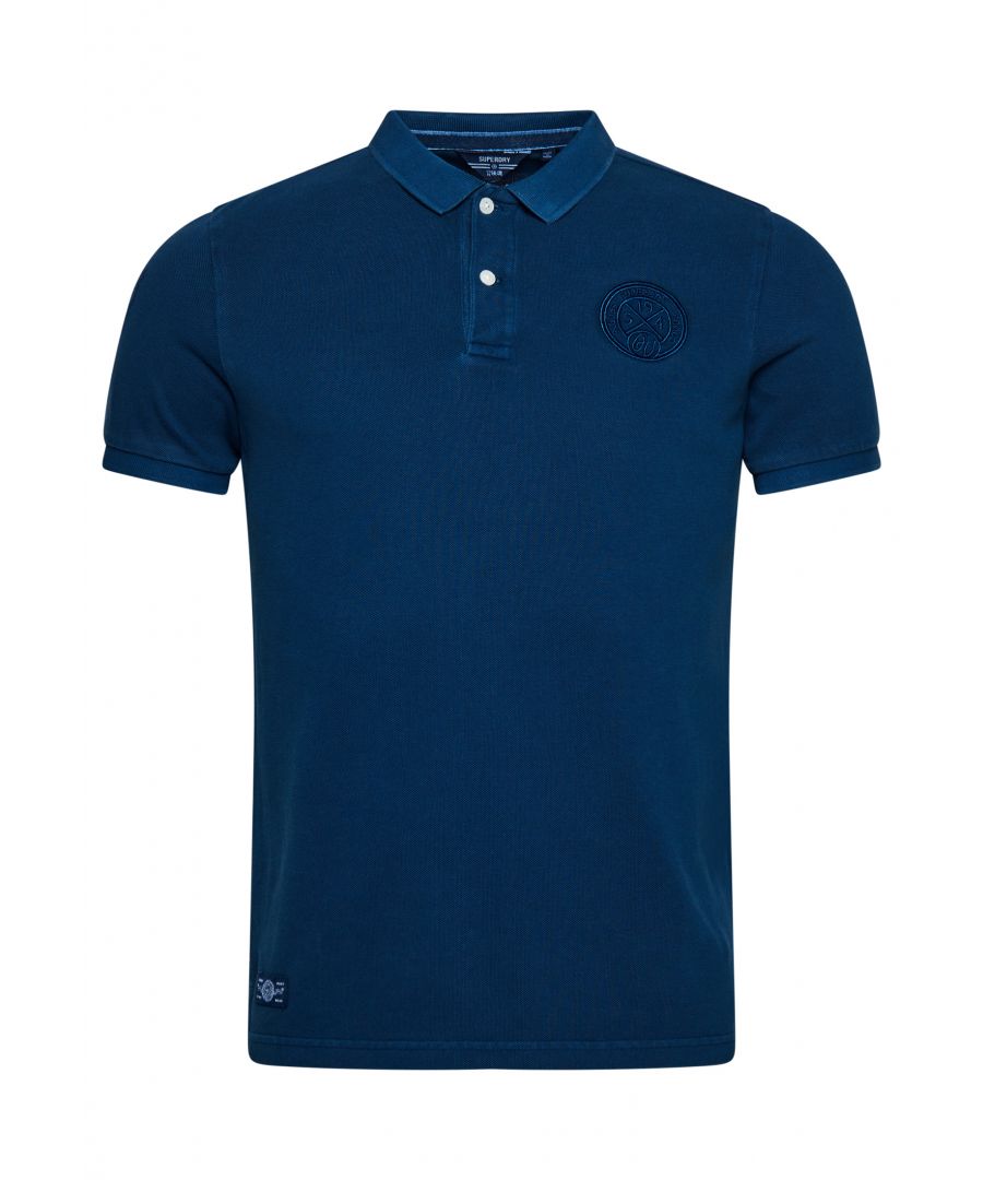 When it comes to our American-styled vintage range, there are few inspirations as classic as the country's love for sport. From football to baseball, an athletic aesthetic has been baked into the spirit of Americana for decades, and this polo shirt embodies that nostalgic culture. Wear it with jeans for a classic casual look.Relaxed fit – the classic Superdry fit. Not too slim, not too loose, just right. Go for your normal sizeOrganic cottonHalf-button fasteningShort sleevesEmbroidered athletics-style graphicsSuperdry tabMade with organic cotton grown using natural rather than chemical pesticides and fertilisers. The healthier soil this creates uses up to 80% less water which is better for our planet and for the farmers who grow it.Sleeve number patch