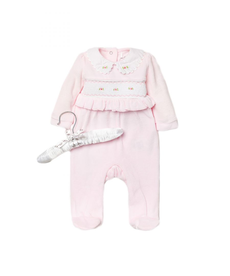 This adorable Rockabye Baby Boutique baby pink, velour sleepsuit features a smocking collar with delicate rose detailing across the band and frill detail. The sleepsuit is footed, with popper fastenings. The sleepsuit is cotton, keeping your little one comfortable. This set comes with a satin hanger, making a lovely baby shower gift for the little one in your life!