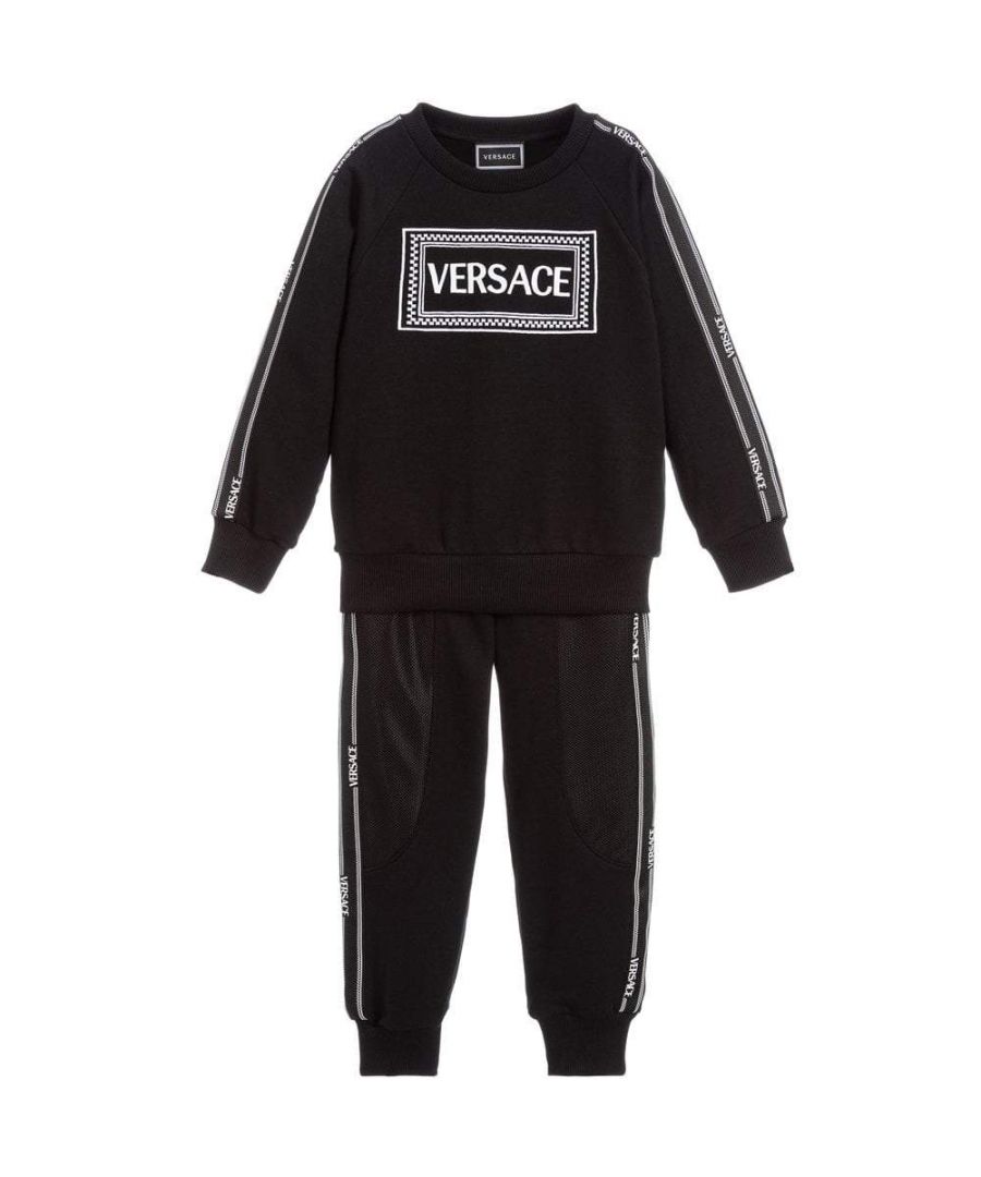 Part of Young Versace's AW19 collection, this black logo sweatshirt and joggers sets feature Versace's signature logo on the front of the sweatshirt and branding running down the arm following down on the leg. The trousers also features mesh paneling by the thigh of the pants and the set is finished off, finished off with ribbed cuffs, hem and waist on both the trousers and sweatshirt.