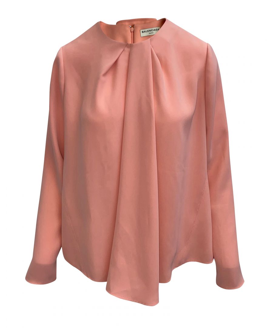 VINTAGE. RRP AS NEW. Look effortlessly chic in this blouse made of polyester in peach. The top is designed with a relaxed fit, long sleeves, a round neck with a pleated neckline that adds a dramatic detail. Pair this top with frayed white denim shorts for a chic and comfortable summer outfit!\n\nBalenciaga Peach Long Sleeve Blouse\nColor: peach\nMaterial: Polyester\nCondition: ITEM IS PRE-OWNED, in very good condition\nSize: M\nLENGTH: 800 mm CHEST: 700 mm WAIST: 640 mm ARM LENGTH: 130 mm \nSign of wear: No\nSKU: 56928