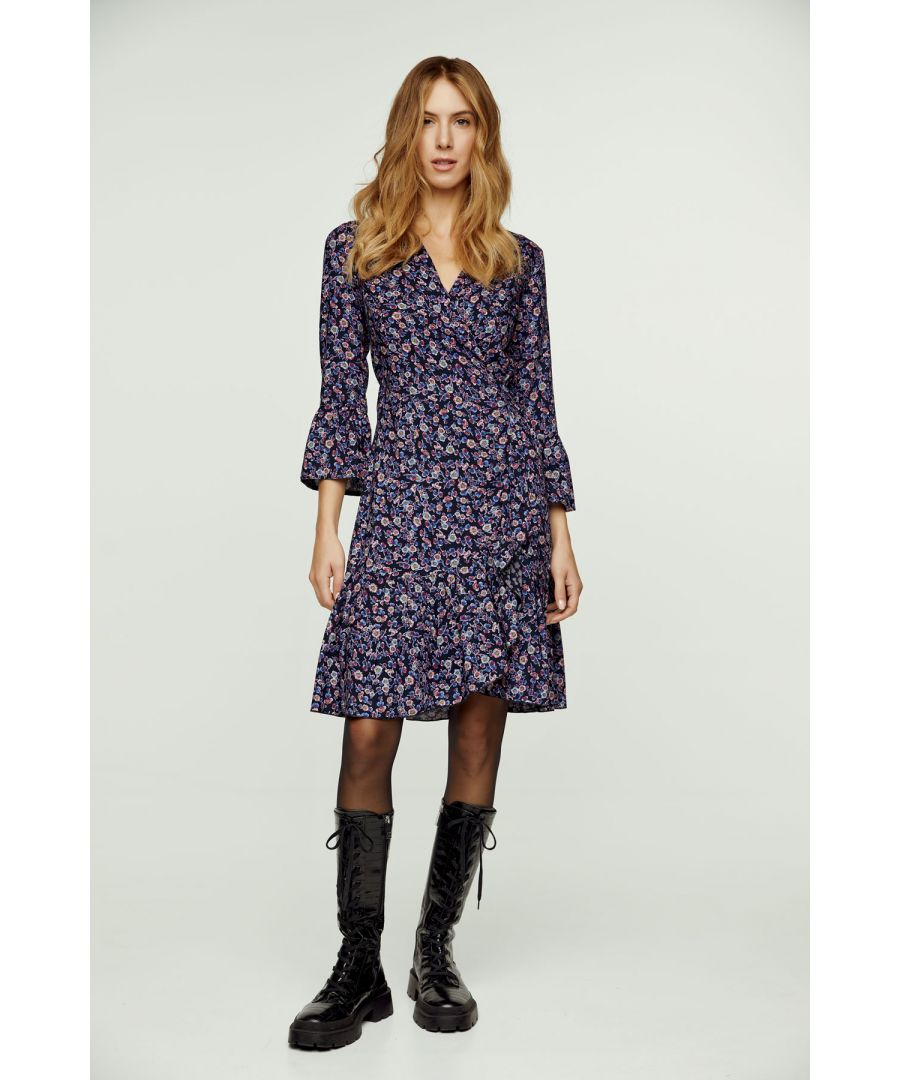 Deze wikkeljurk met bloemenprint is gemaakt van geweven viscose. Hij heeft een V-hals en 3/4 klokmouwen. Deze wikkeljurk heeft een das aan de linkerkant die door een gat aan de rechterkant gaat en die met de rechter das aan de zijkant of aan de achterkant wordt vastgemaakt. In de zoom zit een ruche van ongeveer 15 cm