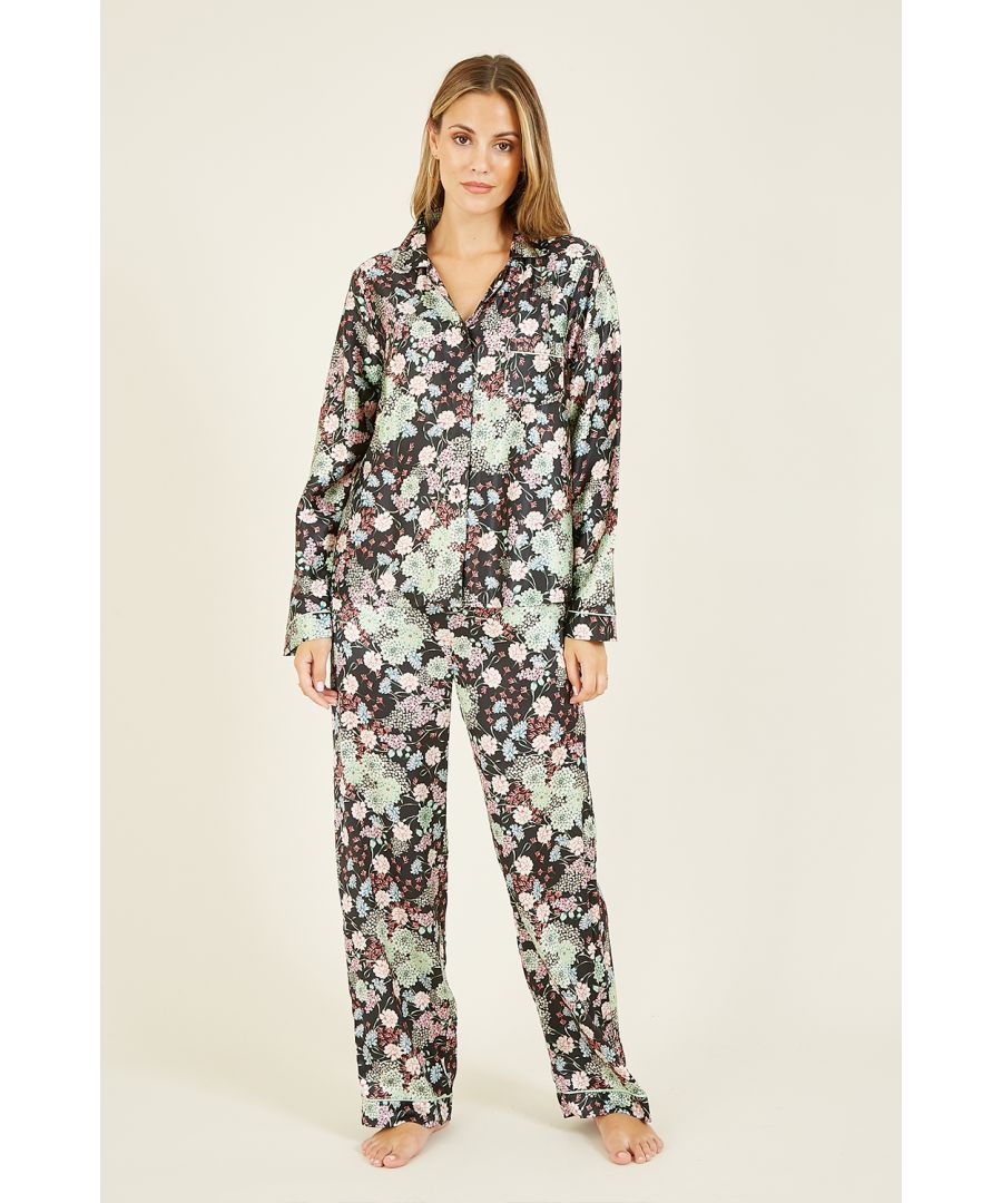 Nachtkleding, maar dan luxe. Deze prachtige pyjama met bloemenprint heeft een volledige knoopsluiting, een kraag, lange mouwen en één zak. Een loose-fit broek en een satijnen pyjamatas maken de 3-delige set compleet. Maatwijzer: S = 8-10 M = 10-12 L = 12-14