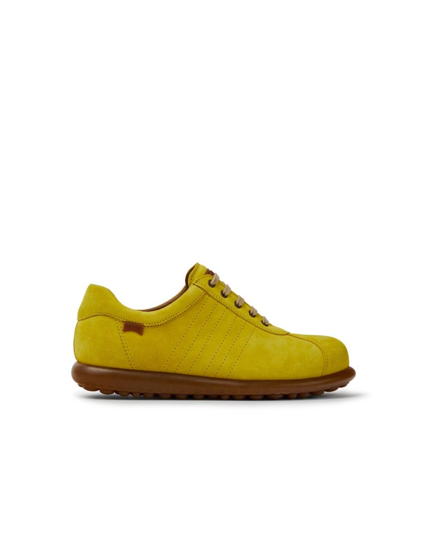 Yellow nubuck women's sneakers with rubber outsoles.\n\nPelotas Ariel is our most iconic Camper style. With an unmistakable, sport-inspired outsole comprised of 87 spheres, each pair is handcrafted from European leathers that is 360º stitched to the original rubber outsole.
