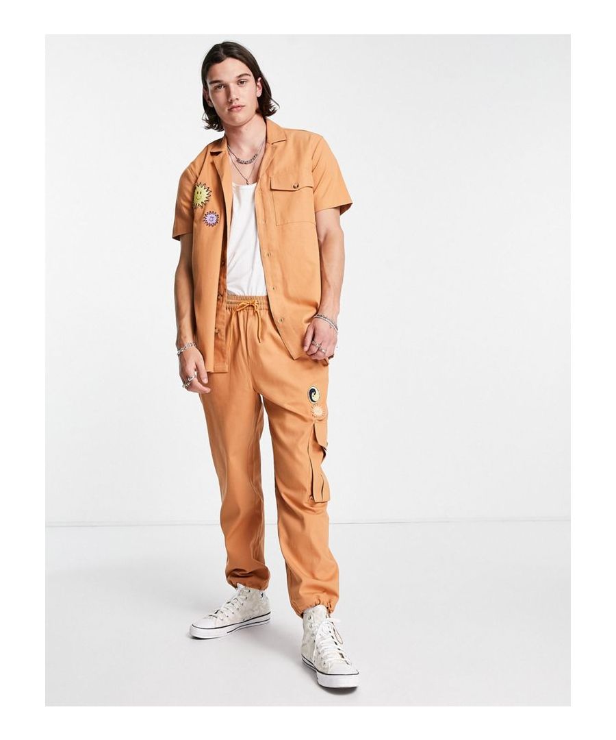 Trousers by Reclaimed Vintage Exclusive to ASOS Shirt sold separately Elasticated drawstring waist Functional pockets Appliques to thigh Regular, tapered fit  Sold By: Asos