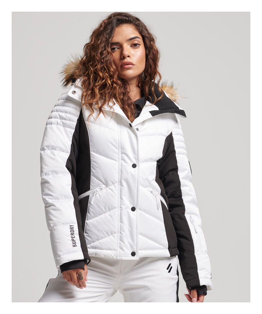 Glide into the ski season with luxurious style in our Snow Luxe Puffer jacket. Equipped with endless ergonomically designed features including a snow skirt, ski pass holder and numerous pockets for your convenience, it's a reliable companion for any adventure. You can ski in sophisticated style with the confidence that you're not compromising on fashion or practicality with this ultimate snowsport piece.Slim fit – designed to fit closer to the body for a more tailored lookCritically taped seams - Key exposed seams are internally taped to help prevent water penetrationBreathable 10k/MM - Provides airflow comfort for low to mid-level activityWaterproof 10k/MM - Rainproof and waterproof under light pressure, for light rainy daysDetachable and adjustable hoodThumbhole cuffsTwo exterior pocketsTwo interior pockets, one with a cloth insertOne sleeve pocketZip and popper fasteningRemovable snow skirtBungee cord adjustable hemSuperdry brandingThe padding in this jacket is made using up to 100% recycled materials.Each jacket contains between 5 and 48 recycled bottles, depending on the weight and amount of fill used, saving waste being sent to landfill or polluting our oceans. 