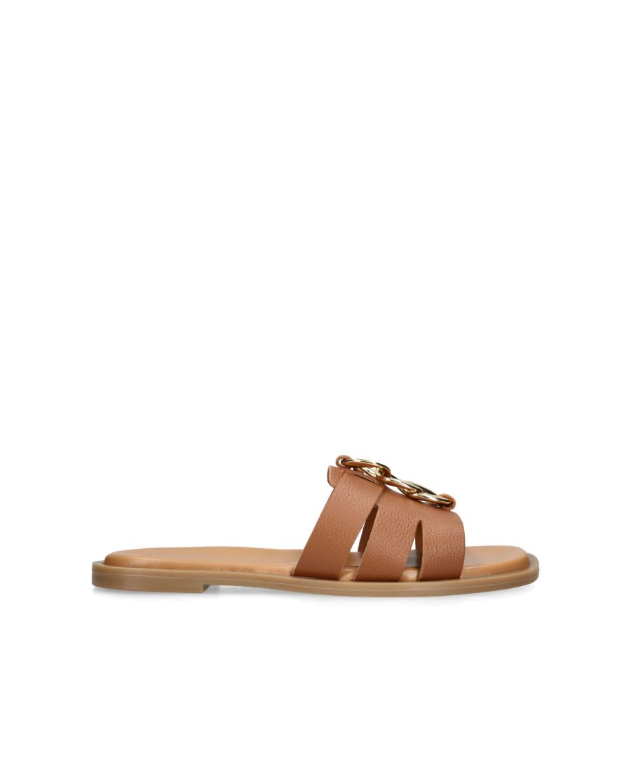 The Raelle is a slip on sandal crafted with a brown leather upper. There is a gold tone chain detail on the strap.