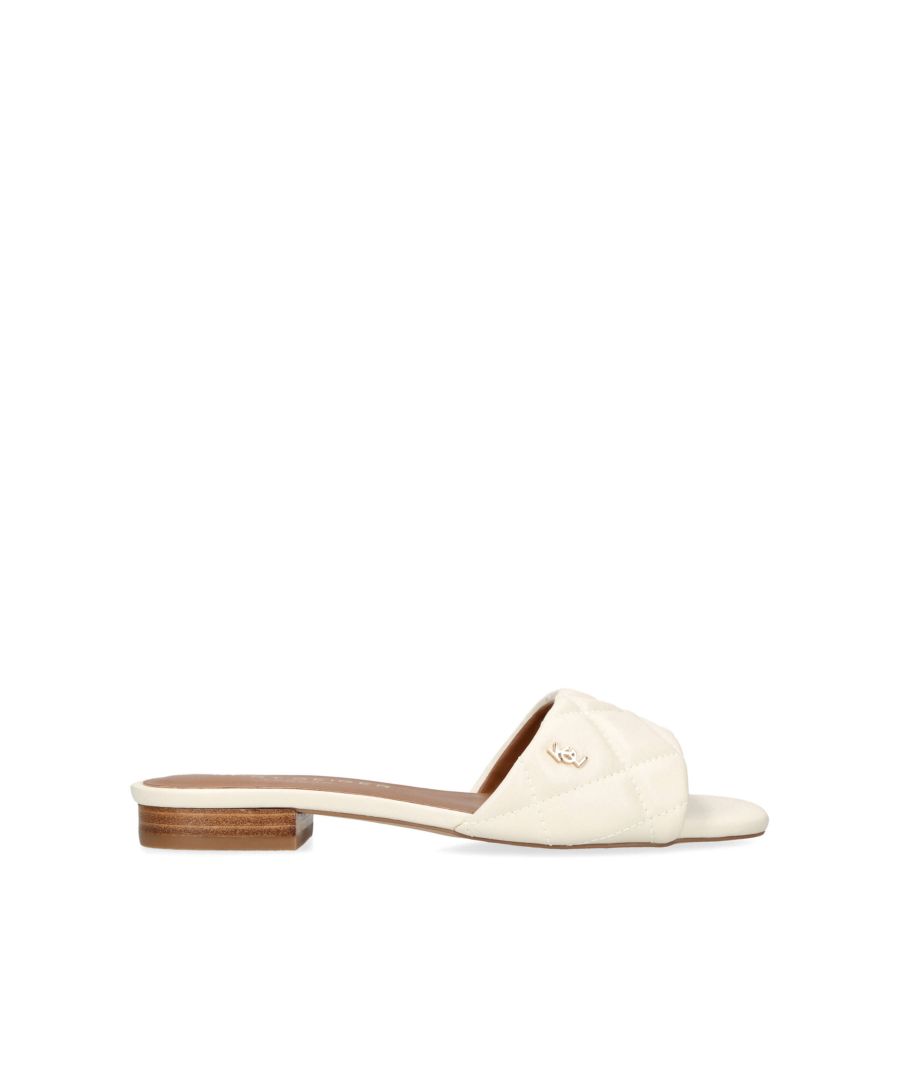 The Kurt Geiger London Brixton Flat features a bone leather upper with overstitch quilt design. There is a small, gold tone KGL stud on the outer side of the toe strap.