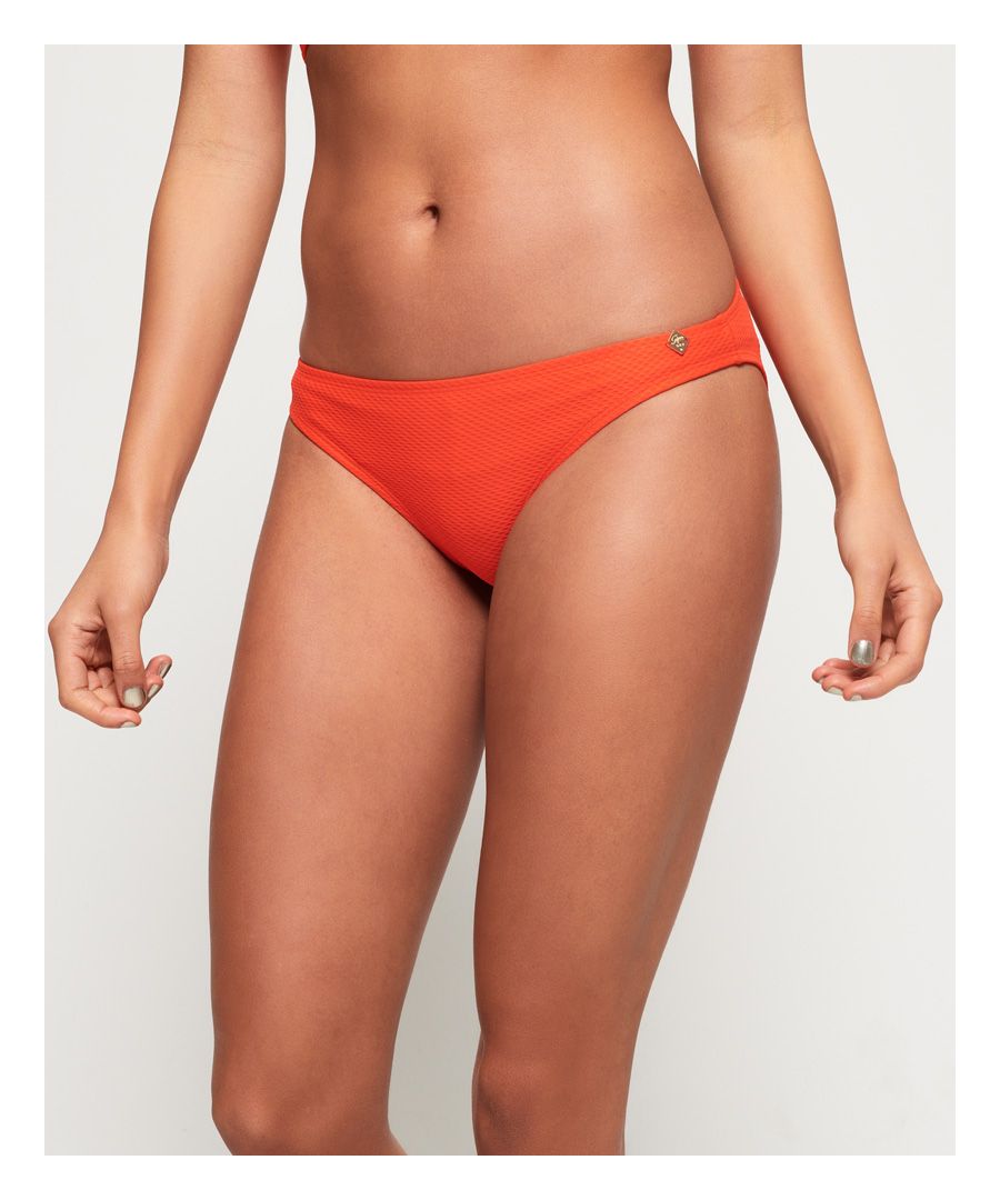 Superdry women’s Sophia textured bikini bottoms. A classic pair of bikini bottoms in a textured design finished with a small, metal Superdry logo badge on the waistband.Please note, due to hygiene reasons we are unable to offer an exchange or refund on swimwear unless the hygiene strip is still intact. This does not affect your statutory rights.