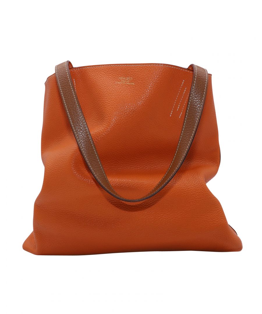 VINTAGE, RRP AS NEW\nThe absolutely reversible Double Sens is the ultimate holdall. An astute sidekick for active women, this super supple, “two-in-one” bag – hence the name – is pure at heart and to be worn close to the body; the best ever.\nTan brown/orange\nCalf leather\nTwo top handles\nOpen top\nMain compartment\nInternal logo stamp\nReversible\nHermès Double Sens Reversible Touch Bag in Brown and Orange Clemence Leather \nColor: Orange\nMaterial: Leather | Calfskin leather\nCondition: Excellent condition with faint marks at the bottom\nL 45 x H 34 x D 13 cm\nSign of wear: Yes\nSKU: 85663   \nSize: One Size