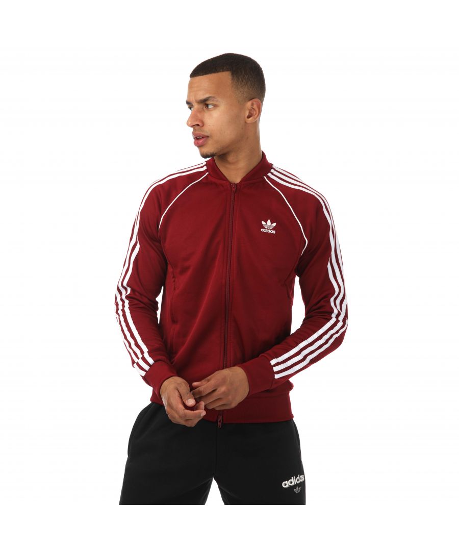 Mens adidas Originals SST Track Top in burgundy.- Ribbed collar.- Raglan sleeves.- Front zip pockets.- Full zip fastening.- Ribbed cuffs and hem.- Contrast piping.- Iconic 3- Stripes.- Regular fit.- Main Material: 60% Polyester (Recycled)  40% Cotton.- Ref: IC4512