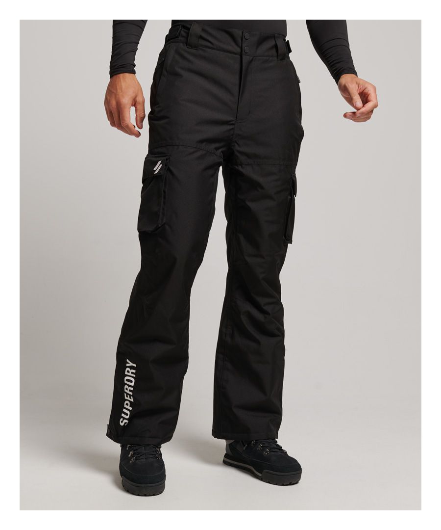 Be ready to explore safely in style with the Ski Rescue pants. Designed to keep you cool and dry, this practical piece is ready to be the staple of the slopes. From skiing to venturing into the outdoors whatever the weather, these reliable pants have you covered.Relaxed: A classic fit. Not too slim, not too tight – no distractions hereDurable water repellency - This fabric has been coated with an advanced water-resistant finishFully taped seams - Seams have been internally taped to help prevent water penetrationBreathable 10k/MM - Provides airflow comfort for low to mid-level activityCoated zips - Zips with a coating that helps prevent water penetrationHook and loop adjustable waistElasticated waistbandBelt loopsZip and popper fasteningTwo zip pocketsTwo popper pocketsZip vent in the inner seamZip and popper fastened cuffsElasticated cuff liningEmbroidered Superdry logoThe padding in these pants is made using up to 100% recycled materials.Each pair contains between 6 and 13 recycled bottles, depending on the weight and amount of fill used, saving waste being sent to landfill or polluting our oceans.