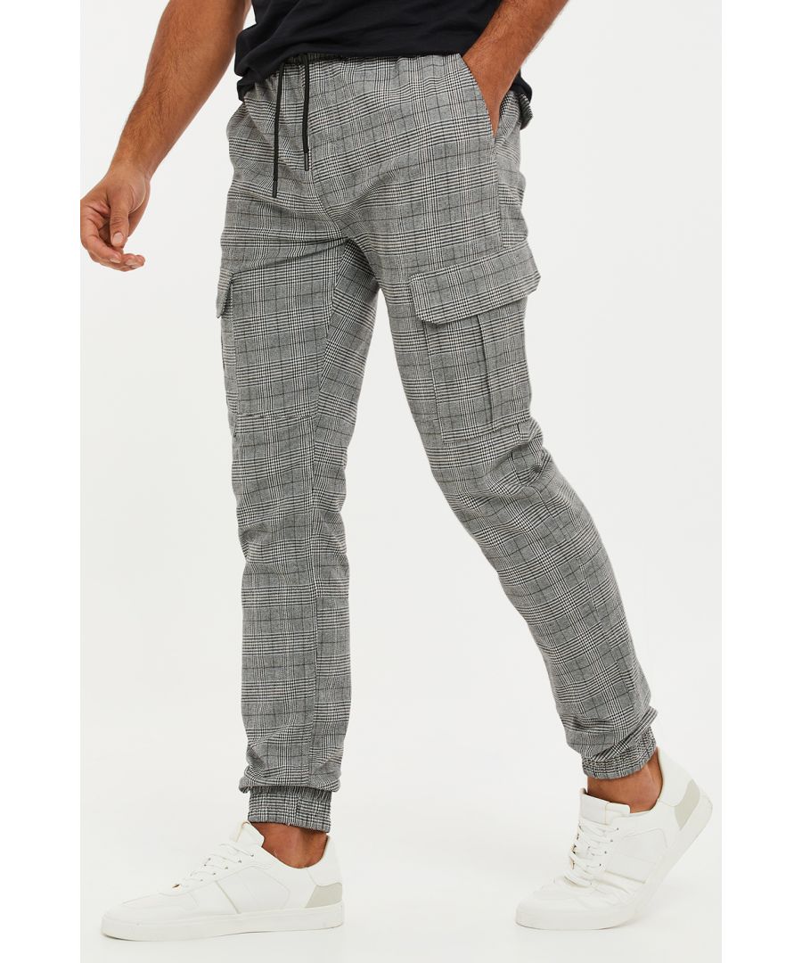 Upgrade your casual wardrobe with these checked cargo trousers from Threadbare. Designed in a slim fit, these jogger like cuffed trousers feature a cargo pocket on each leg and front and back pockets. An elasticated waistband with zip fly and drawcords finish this easy style which contains a little stretch for comfort. Throw on a hoodie and a padded gilet for an off-duty look, or add a plain white t-shirt and a shacket for a laidback luxe feel.