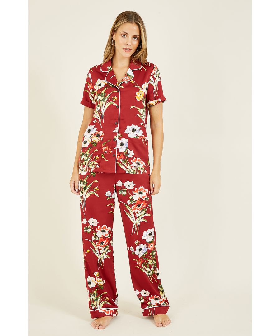 Sleepwear, but don't sacrifice style. This silky satin oriental style red three piece pyjama set from Yumi boasts a bold floral print, complete with contrast white piping. The top comes with a button through fastening, collar and short sleeves, with loose fitting trousers and a satin bag to match.