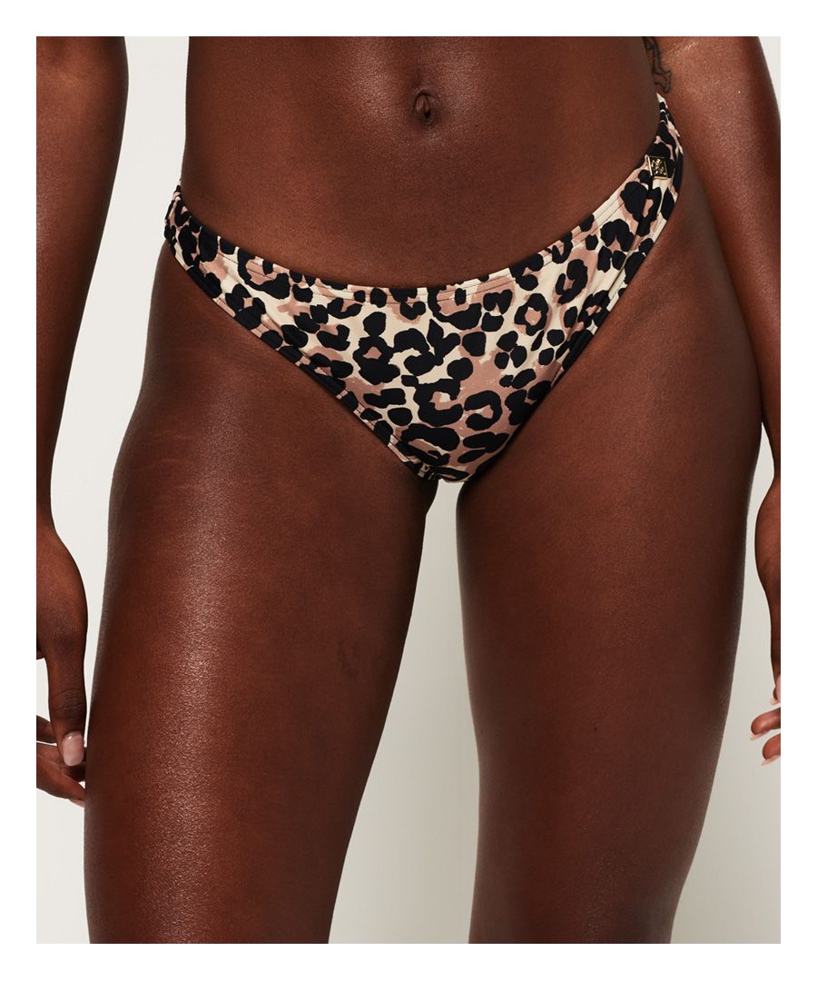 Superdry Leopard Cheek-bikinibroekje voor dames. Een stoer bikinibroekje met luipaardprint en afgewerkt met een metalen Superdry-logobadge op de voorkant.Bijpassend broekje apart verkrijgbaar.Om hygiënische redenen kan badmode uitsluitend omgeruild of geretourneerd worden als de hygiënestrip nog intact is. Dit doet geen afbreuk aan je wettelijke rechten.