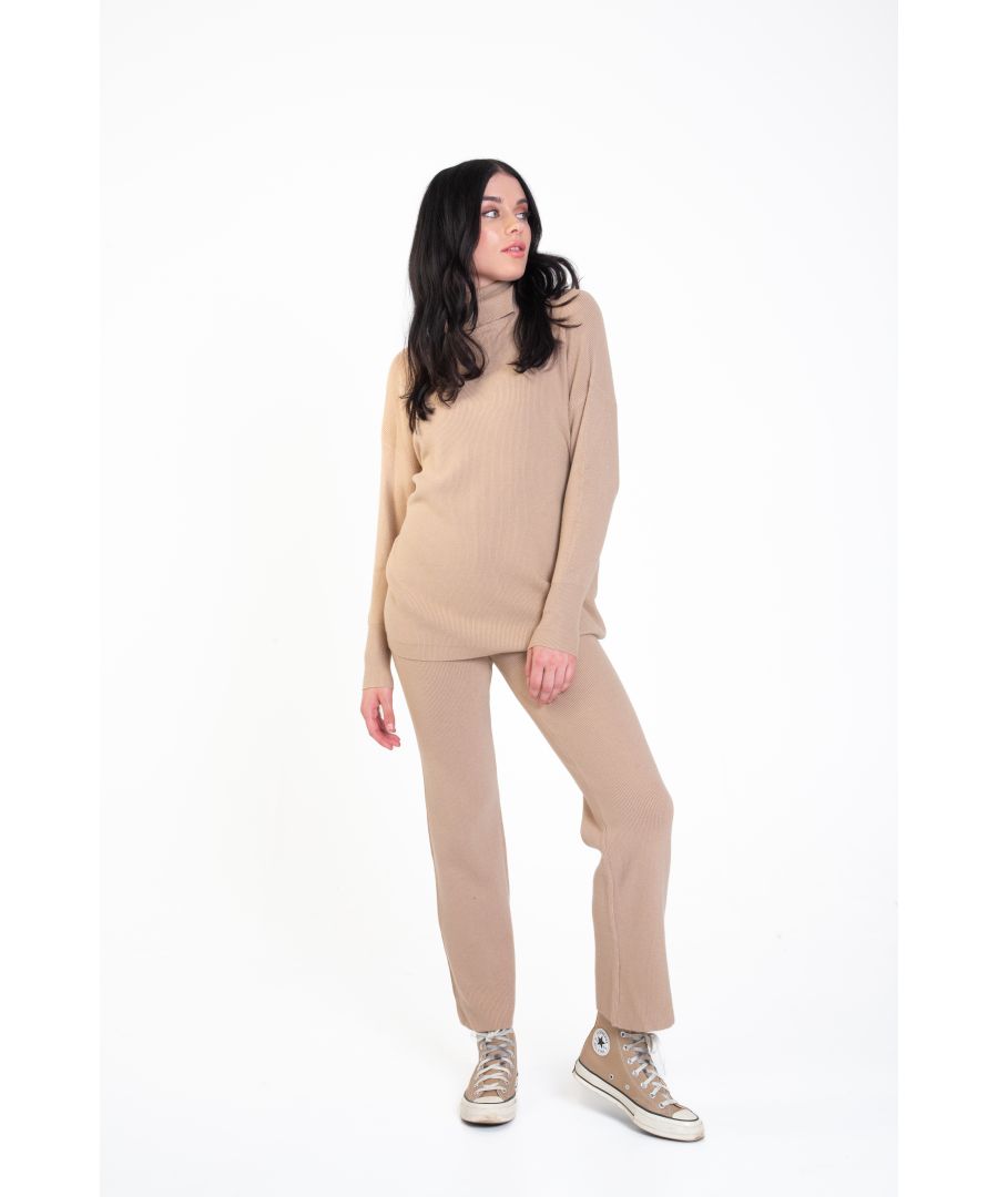 With our Roll Neck Knit Jumper and Trousers Set, you can relax in style. Featuring an oversized knitted top with a rolled high neck, dropped shoulders, and long ribbed cuff sleeves, make a statement with the matching trousers and a new pair of white sneakers. This matchy-matchy trend is always on, as co-ord sets simplify style for an off-duty look.