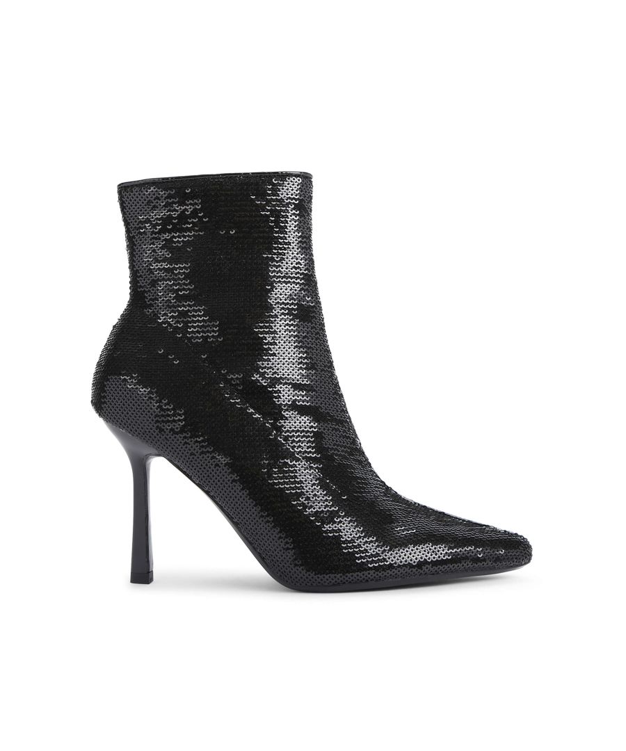 The Attention Ankle Boot features a black sequin upper and stiletto heel in black. There is a golden pull tab on the inner side zip.