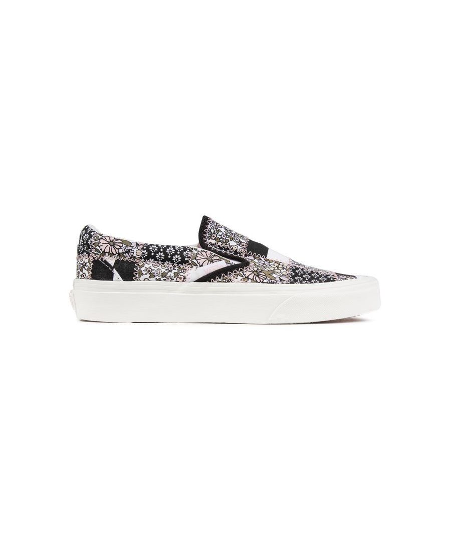 Women's Black Canvas Vans Classic Slip-on Sneakers With A Pink, Black And White Patchwork Print Pattern And Elasticated Bandana Detail. These Ladies' Low-profile Pumps Have A Soft Canvas Lining And Sock, Rubber Vulcanised Outsole With Iconic Off The Wall Heel Tab.
