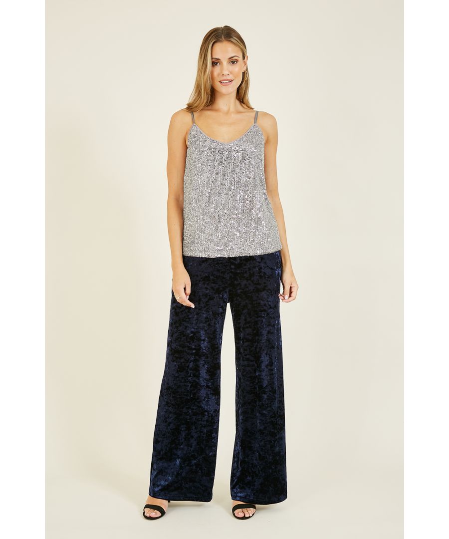 Sparkle this season in this Yumi Silver Sequin Vest Top. A stunning, all-over seqinned, statement vest top in a striking silver, Features cross back skinny staps. Perfect partywear, matched with skinny jeans or leather trousers and an oversized blazer.