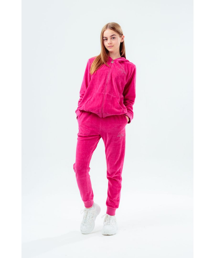 The HYPE. fuchsia velour diamante logo kids tracksuit set is the perfect loungewear choice when you need a lil extra comfort and style. In a velour fabric base for supreme comfort in our standard unisex kids jogger shape, highlighting an elasticated waist, cuffs and pockets. Featuring a fixed hood, pouch pocket and fitted cuffs. Finished with the iconic HYPE. script logo in diamante stones.