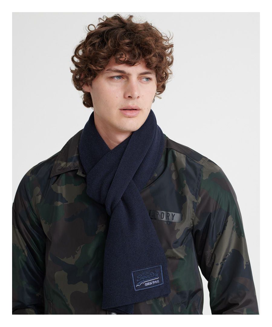 Superdry men’s scarf from the Orange Label range. This cotton scarf is a wardrobe staple and can be worn with anything. This soft, knitted scarf features an embroidered Superdry logo above the hem.
