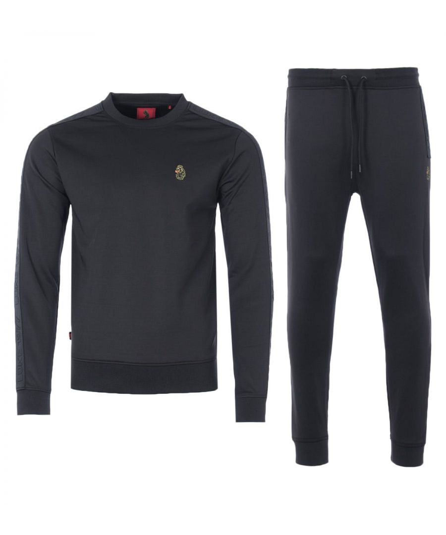 M470340SETBLKMens Trico TracksuitMens Luke 1977 Trico Tracksuit in black. - Sweatshirt:- Crew neck.- Ribbed trims.- Luke 1977 raised text tape detailing at the sleeve.- Luke lion embroidery on chest.- 94% Polyester  6% Elastane. Machine washable.- Pants:- Drawstring waist.- Ribbed cuffs.- Two front pockets. One back pocket.- Branded taping at slit pockets.- Luke 1977 logo embroidered at left thigh.- Regular Fit.- 94% Polyester  6% Elastane. - Ref: M470340SETBLK