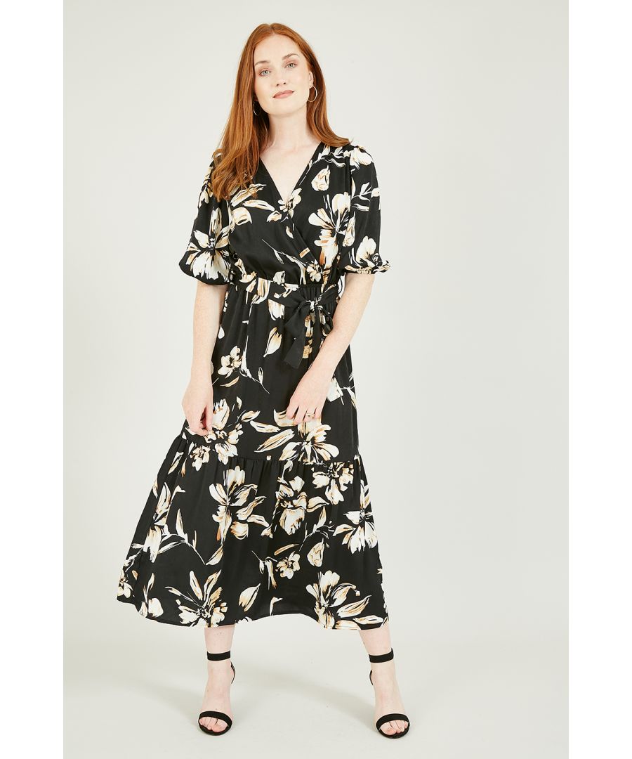 Refresh your wardrobe classics with this timeless Mela Black Floral Wrap Midi Dress. Comes in a super flattering cut, with a wrap around shape, waist tie belt, elbow length cuffed sleeves and a stunning, black and cream floral pattern. A piece to see you through the seasons. Match with heels or flatform trainers.