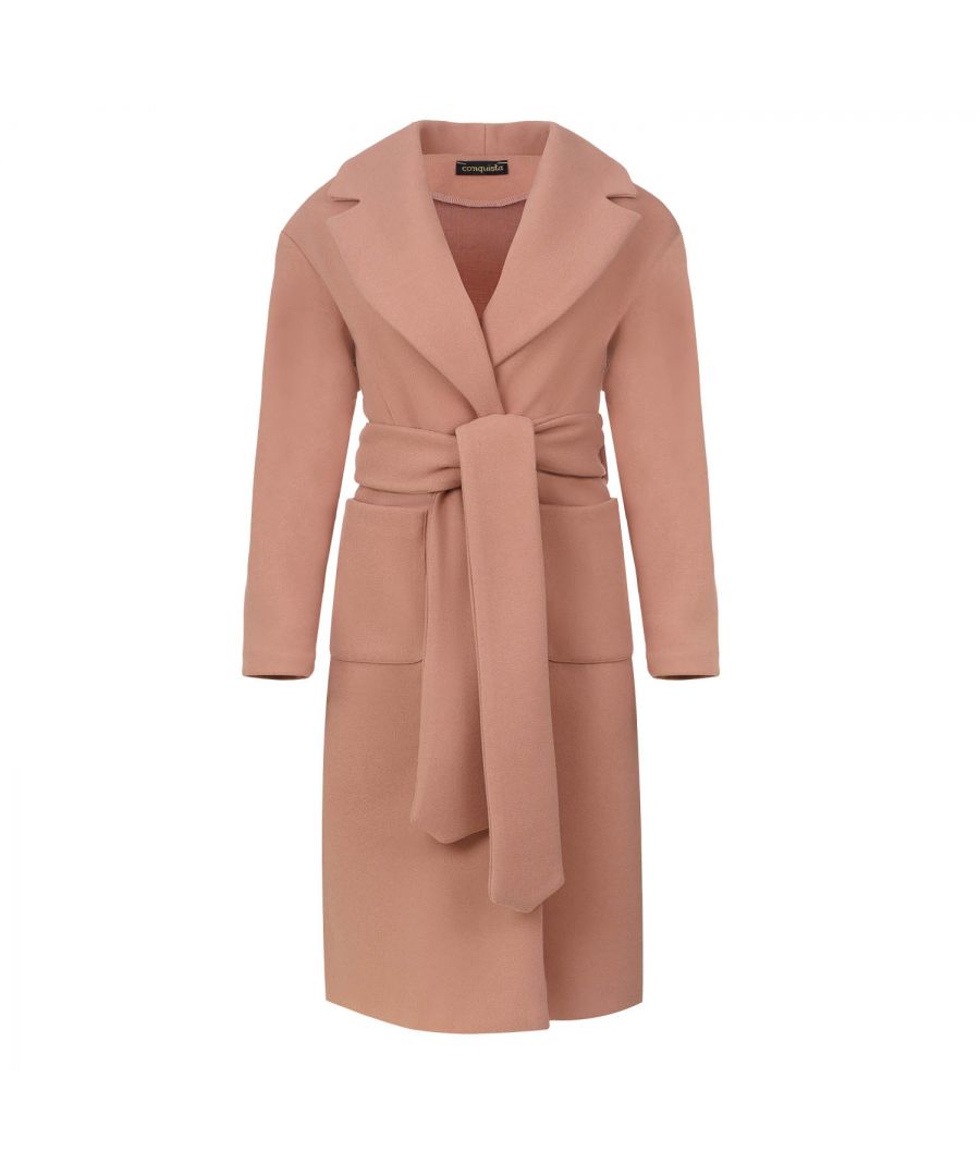This long salmon colour coat is crafted in faux mouflon style fabric. There are large square patch pockets on either side. It has a large lapel and drop shoulders. The coat fastens in the front with 2 large black plastic buttons. At the waist it has belt loops on the left and right so that it can be worn with the 9cm wide belt which is in the same fabric. The coat has big slits on either side. It is styled in a straight silhouette.  This piece is ideal for wear in the day or for an evening out.