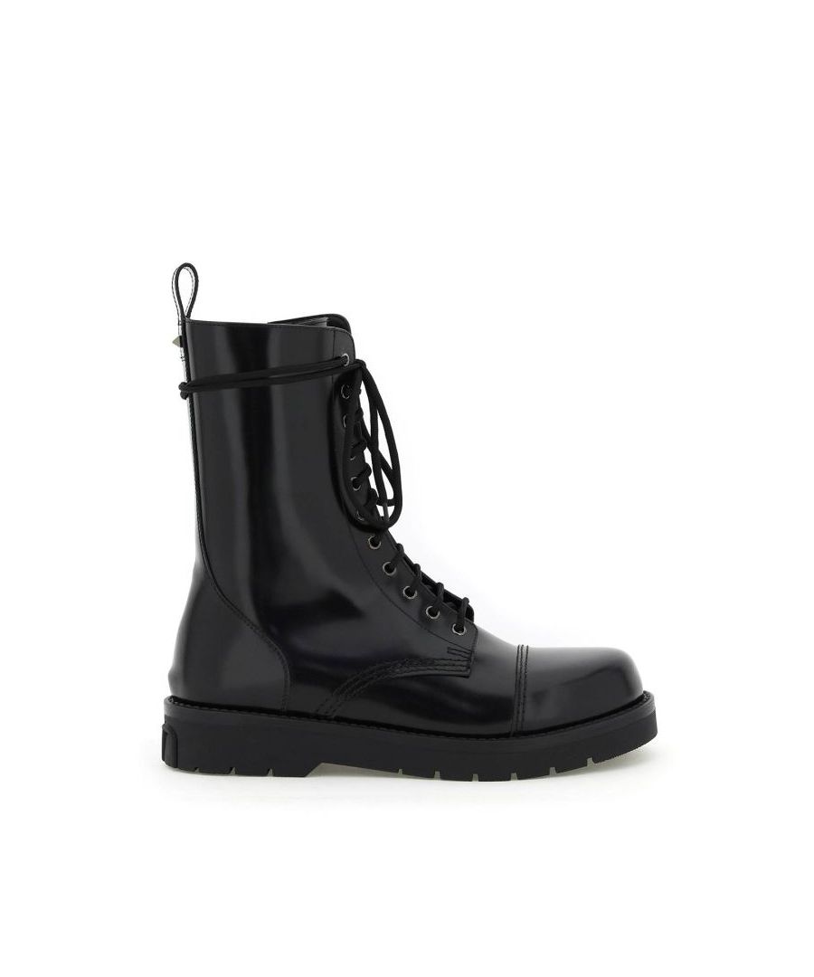 Camden Shoes lace-up combat boots by Valentino Garavani crafted in brushed calf leather with side zip closure and rear loop tab enriched with the iconic metal stud. Leather lining, rubber sole with embossed studs on the tread and V-Logo Signature on the back. Ruthenium-finished metal ware.