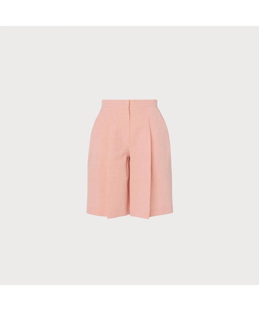 In the palest shade of baby pink, our Sweetpea shorts work beautifully with separates or as part of a suit with the Sweetpea jacket. Crafted from a beautiful linen-blend Italian fabric, these vintage-inspired shorts have a wide, tailored cut, they sit on the waist and have an exaggerated central pleat. Wear them with the matching jacket with courts and a printed top, or simply with a crisp white tee and flat leather sandals.