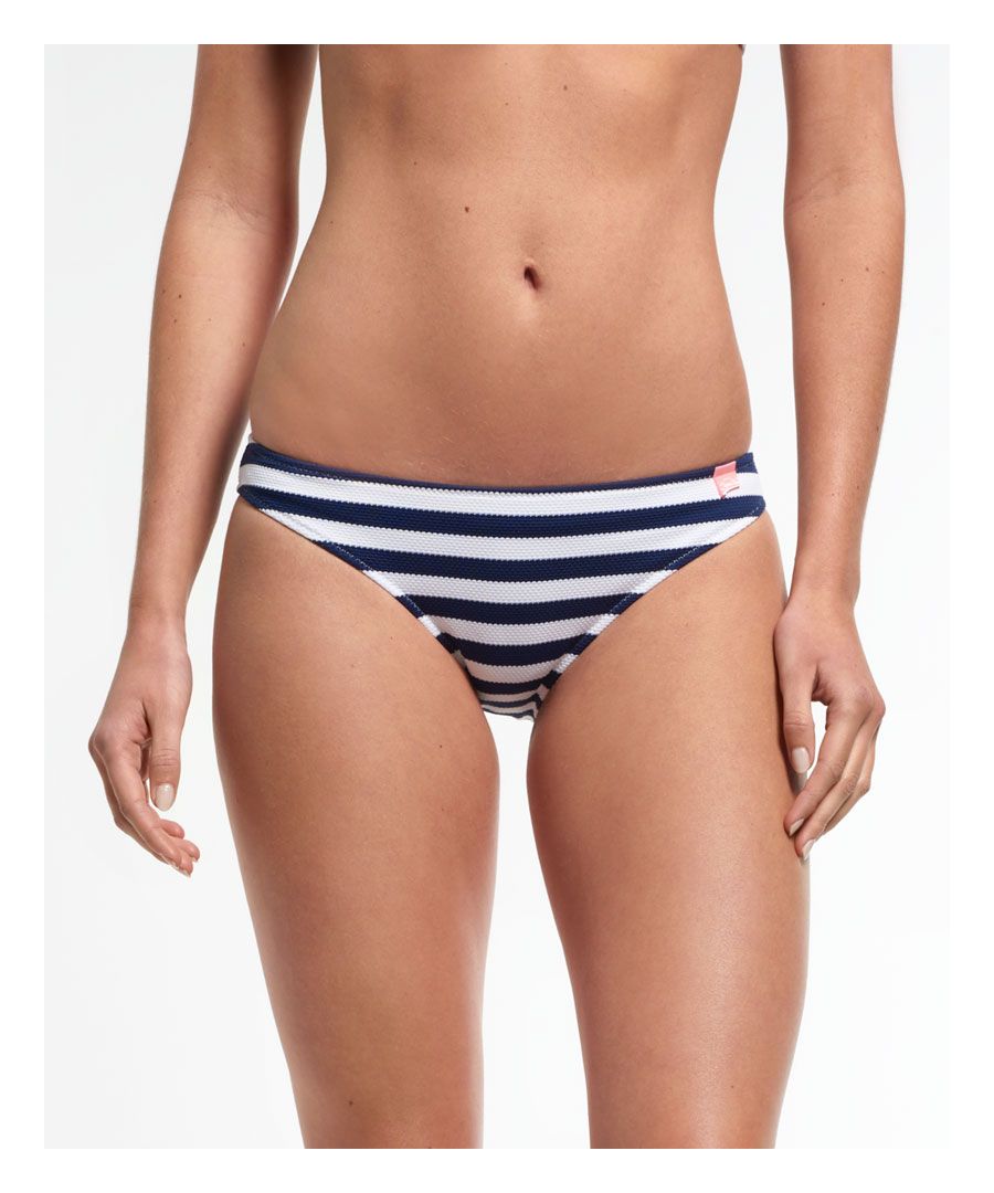 Superdry women's Marine Stripe Bikini Bottoms. Classic bikini bottoms featuring an all over stripe nautical style design and finished with a small rubber Superdry logo on the hip.  Please note due to hygiene reasons, we are unable to offer an exchange or refund on swimwear unless they are sealed in their original packaging. This does not affect your statutory rights.Model wears: Small Model height: 5’ 10” (178cm)