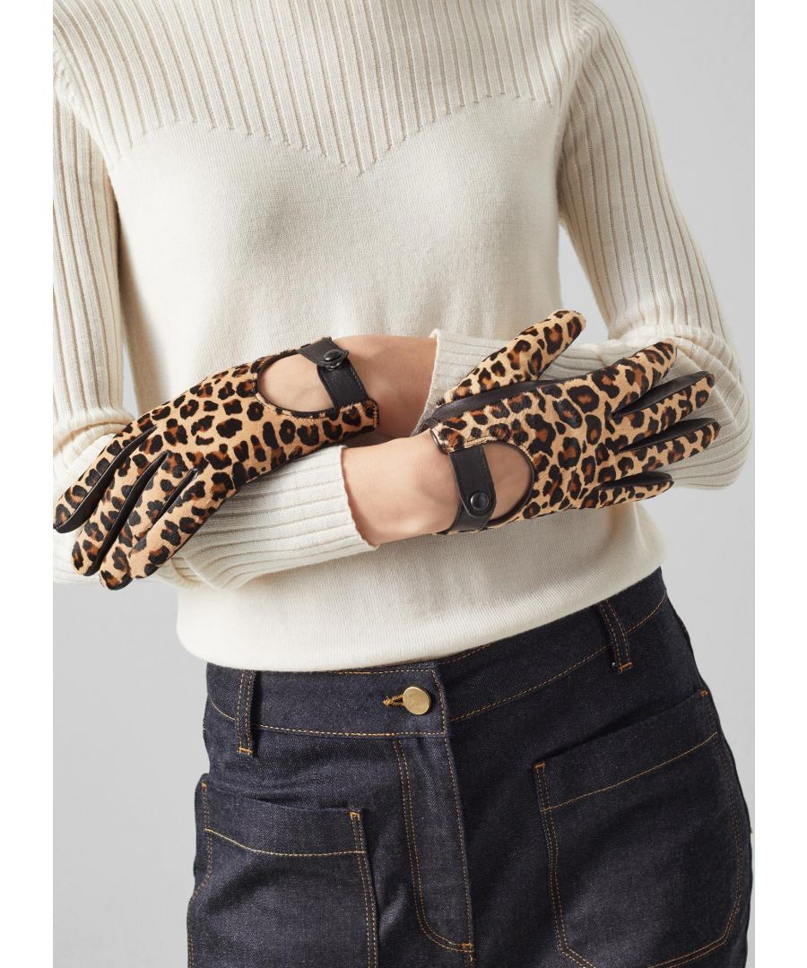 A printed pair of winter gloves instantly adds a pop of colour and playfulness to simple winter looks. Our Laura gloves are a driving glove style crafted from luxurious leopard print calf hair and butter-soft black leather. They’re a chic, timeless style with black popper detail to the back of the hand.