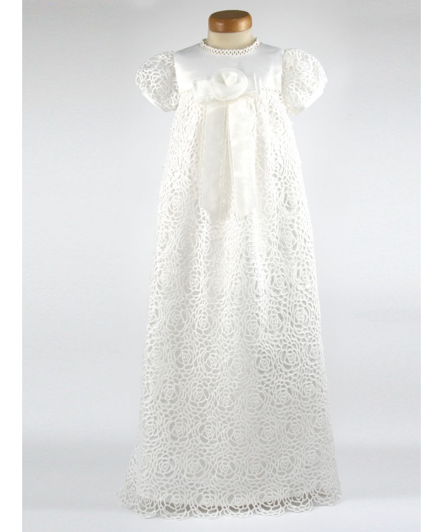 We have reintroduced one of our popular gowns - Ruby. \n  \nA stunning Christening robe made with Guipure Lace. A full length dress with a satin bodice, lace sleeves and a beautiful front detail of an organza flower on stunning ribbon tails.  Your child will look very special on the day! \n  \nWe line our dresses and robes in 100% lightweight Cotton lawn fabric which is cool and better against babies body, especially if they have sensitive skin \n  \nThe gown arrives to you on a padded Satin hanger and protected by one of our Heritage keepsake garment bags. \n  \nOuter - 100% Polyester Mock Silk - Ivory \nLining - 100% Cotton \nDry Clean or Hand Wash