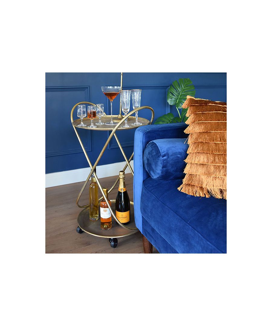 Looking to step up your hosting prowess? Look no further. With this large drinks trolley, finished in a decadent glowing gold, you won’t ever need to choose between ‘going big’ or ‘going home’ again, because you can do both! Combining modern minimalism with the golden opulence of the roaring ‘20s, this golden drinks trolley is bound to bring some visual excitement to your home, elevating your environment with ostentatious glamour.\nWhether you’re looking for extra storage space or hoping to win the next edition of Come Dine with Me, you won’t be wanting to roll this domestic prize away! With an Art Deco aesthetic worthy of belonging in a decorous Great Gatsby scene, this bar shelf trolley oozes opulent allure. With enough space to indulge every guest’s predilection, the large round drinks trolley comes equipped with a handlebar and wheels for ease of movement. Home accessories need not only provide aesthetic charm, but also functionality in excess – the large gold drinks trolley attests to this fact.\nA sumptuous extra-storage solution, this shelf trolley provides versatility, equally as suited to home bars as it is home offices. Rendered in a timeless gold finish, the trolley combines Art Deco majesty with sleek serviceability.\n \nFeatures:\n\nTwo shelves\nWheeled for mobility\nGold finish\n\n \nProduct Specifications:\n\nProduct Type: Drinks Trolley\nWeight: 2.98kgs\nDimensions: H78cm x W49cm x D43cm\n\n \n 