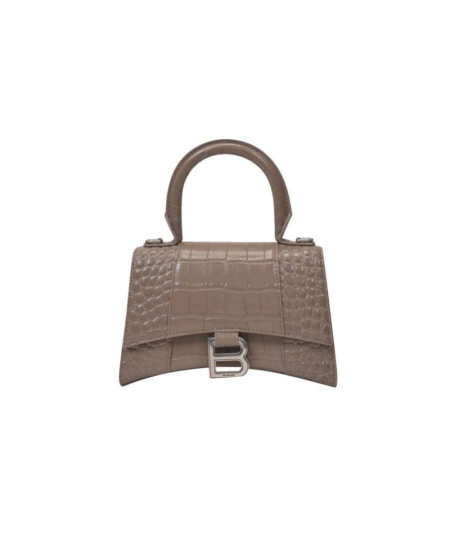 This luxury handbag from Balenciaga will bring elegance and sophistication to any outfit, day or night, thanks to its already iconic hourglass shape. Top handle : 10 cm - Crossbody strap : 110 cm. Worn two ways - one top handle and one adjustable detachable crossbody strap. Material : croc-embossed calfskin. Lining : leather. Colour : Gris - 1212 Mink Grey. Closure : flap with magnetic closure. Interior: one zipped pocket, one flat pocket.