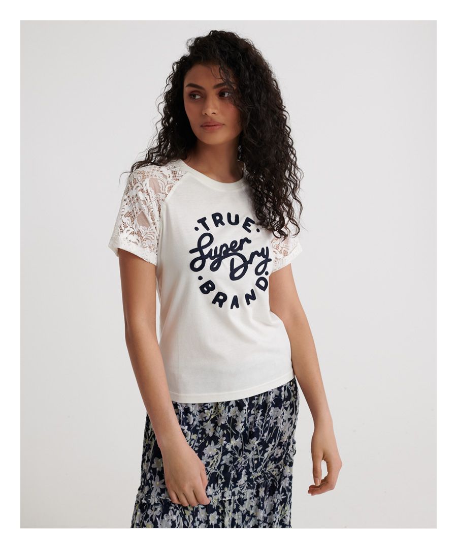 Superdry Summer Lace Raglan T-shirt voor dames. Dit T-shirt in raglanstijl heeft een groot Superdry-reliëflogo op de borst, kanten mouwen en een Superdry-logolabel op de zoom.