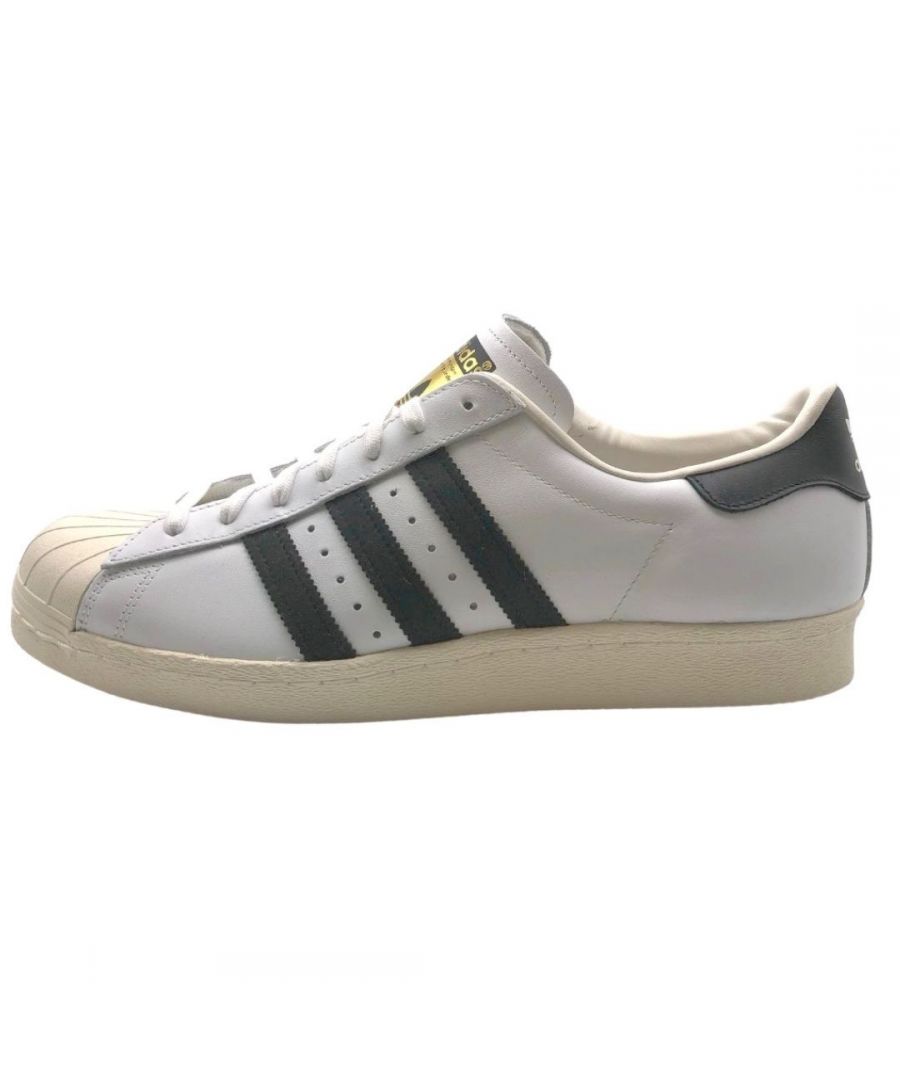 Adidas Superstar 80s Mens White Sneakers. Textile Material Upper, Rubber Sole. Style: G61070. Classic Superstar 80s Style. Lace Fasten Trainers. Branding On Side Of Shoe And Tongue