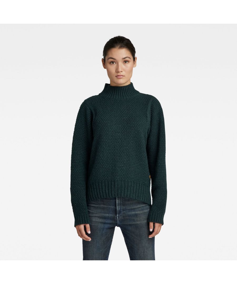 Turtleneck. Long sleeves- ribbed cuffs. Straight hem, ribbed edge. Side slits. Graphic labels at the lower front and back. No closure. This knitted sweater is knitted from wool,  blended with super-soft alpaca and polyacrylic yarns. Medium weight knitted structure. Soft texture. Straight