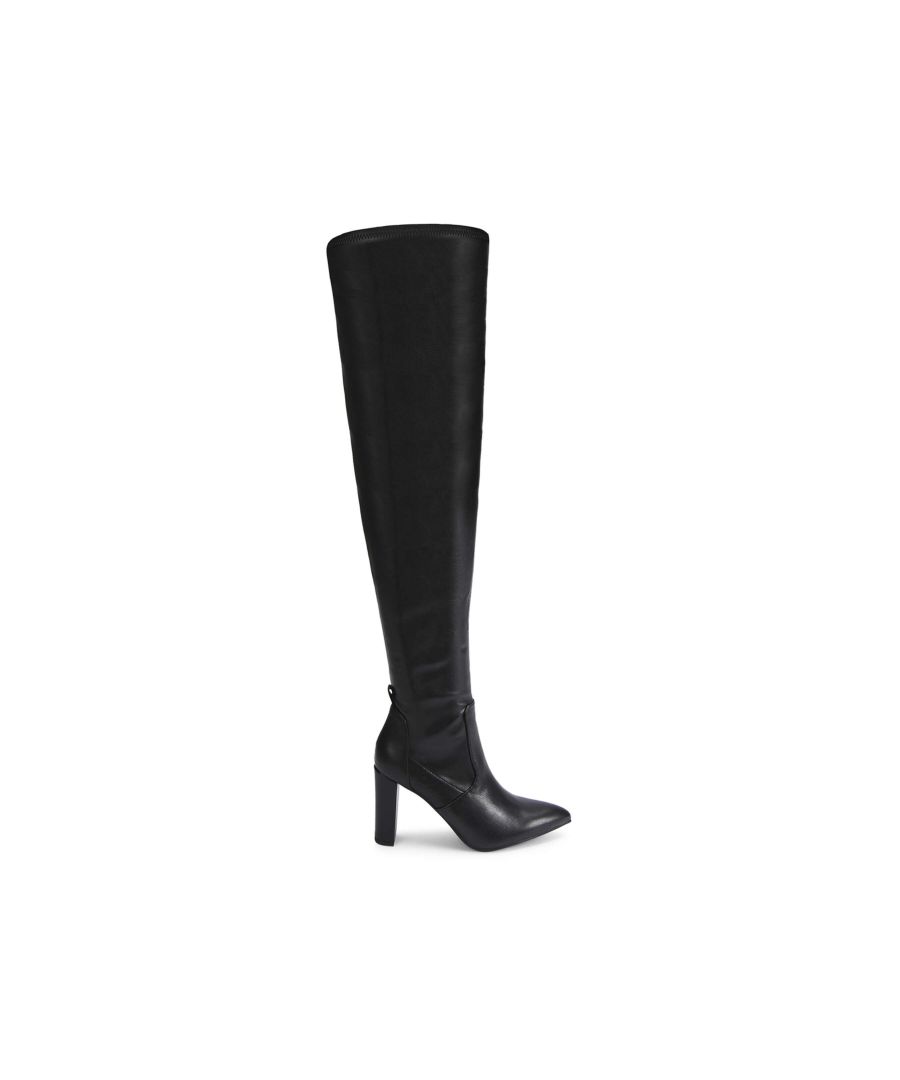 This Suri is an Over The Knee boot in black. There is a KG Kurt Geiger logo printed on ribbed textile with a print stitch detailing tab at the back of the ankle. Heel height: 9cm. Concealed zipper on the inner sides. This product is registered with The Vegan Society.