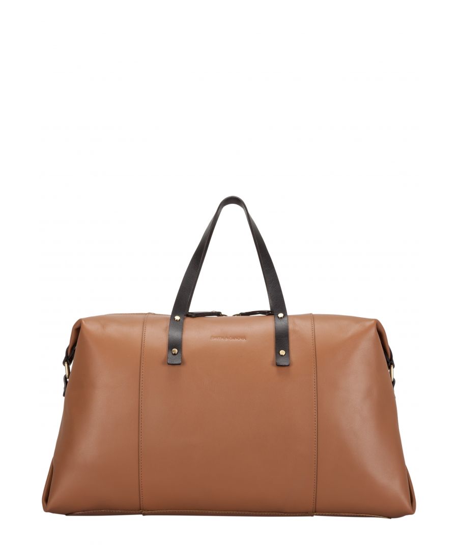 The Asquith holdall is made from genuine leather, with a smooth exterior. The gold stud detail is enhanced by the delicate stitch detail. The contrast leather handle and tab detail adds further interest. The styling is simplistic, minimal and Scandinavian inspired. Features: , Genuine leather, Smith & Canova blind debossed logo, Contrast leather handle and tab detail, Zip top opening, Delicate stitch detail, Gold stud detail