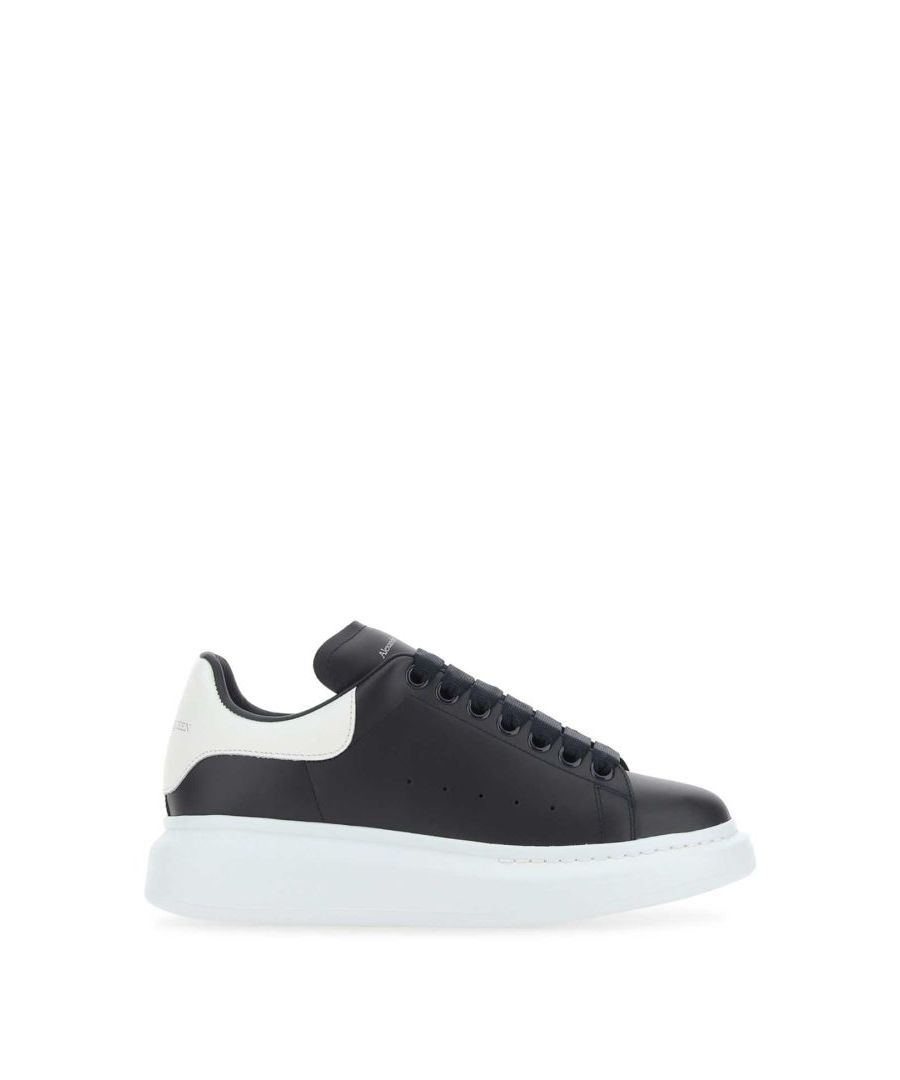 Black leather sneakers with white leather heel.