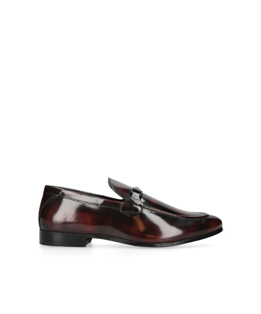 The Charlie is a formal flat shoe crafted in a wine high shine leather. There is a gunmetal chain sat across the foot. Material: Leather.