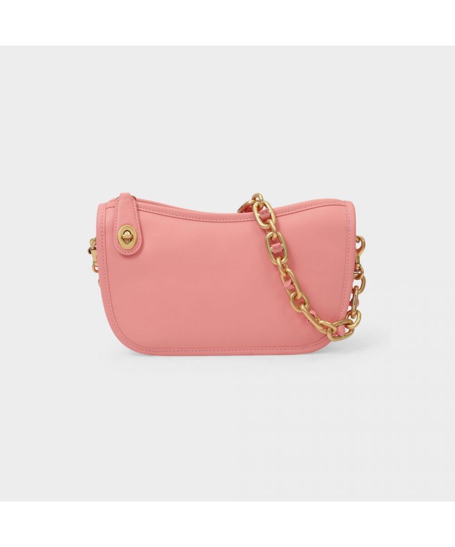 Inspired by the Coach house archives, the Swing bag is all about the nineties. A compact, practical piece, you will love for its utterly original curves. Wear it on your shoulder with a crop-top, baggy trousers and a pair of chunky sneakers for a truly fun and retro look. Top handle : 17 cm. Carried by hand - One top handle and one detachable shoulder strap. Material : smooth calfskin. Lining : cotton. Colour : Pink - B4/Candy Pink. Closure: top zip. Interior: one flat pocket.