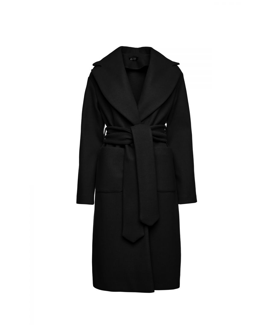 This long black coat is crafted in faux mouflon style fabric. There are large square patch pockets on either side. It has a large lapel and drop shoulders. The coat fastens in the front with 2 large black plastic buttons. At the waist it has belt loops on the left and right so that it can be worn with the 9cm wide belt which is in the same fabric. The coat has big slits on either side. It is styled in a straight silhouette. This piece is ideal for wear in the day or for an evening out.