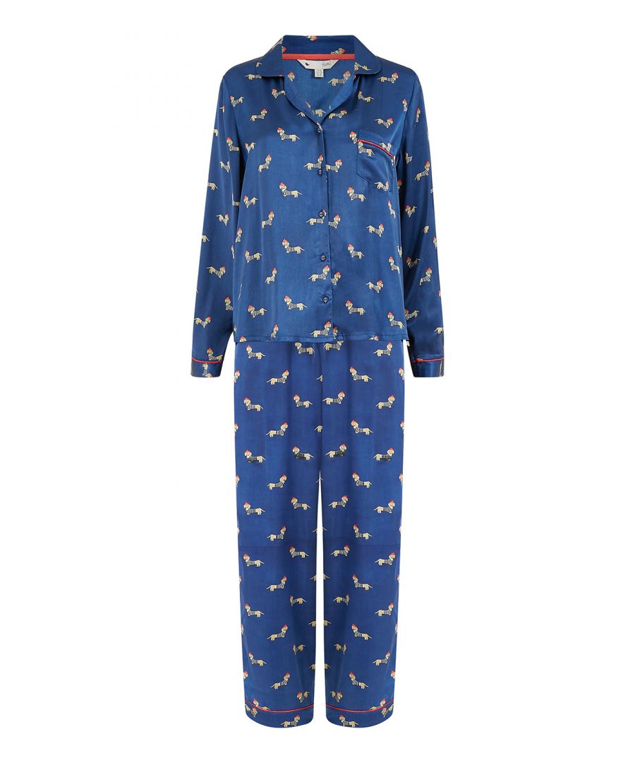 Slaapkleding, Yumi-stijl. Deze satijnen pyjama is zijdezacht en bijzonder luxueus. Met een prachtige door Yumi ontworpen teckelprint, afgewerkt met contrasterend rood biesje. De top heeft een knoopsluiting, een kraag, lange mouwen en één zak. Een losvallende broek maakt de set compleet. Verwen jezelf met deze driedelige set, compleet met satijnen pyjamatas. Ook perfect om als cadeau te geven.  Maattabel: 16-18 (reële maat) 20-24 (vallen kleiner, meer richting maat 20) 26-28 (vallen kleiner, meer richting maat 26)