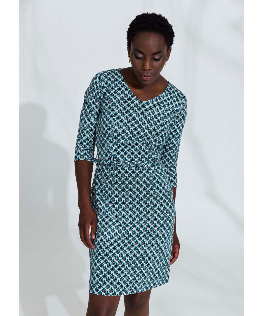 Blauwe jurk met repetitief plantenpatroon. De jurk heeft een aansluitende top, met een ronde halslijn, halflange mouwen en een rechte rok. De jurk heeft een bijpassende riem om de taille te benadrukken.