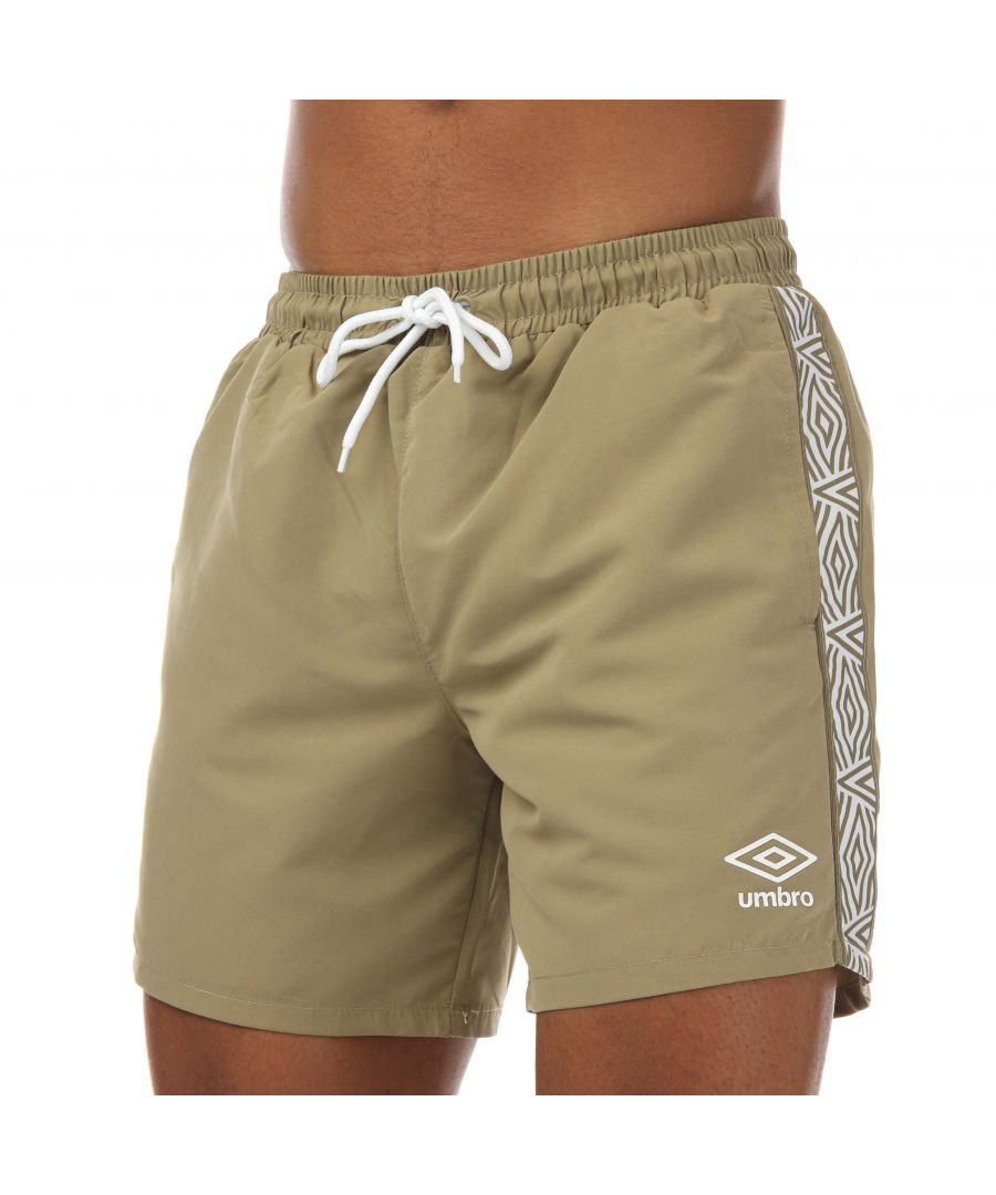 Mens Umbro Taped Swim Shorts in khaki.- Elasticated bungee hang loop to TW Navy rear external waistband.- Internal small items storage pouch with velcro fasten.- Side slip pockets.- Lock zip pocket.- Contrast high build Performance Logo print to leg.- Contrast piping to rear auto.- Tape running down side legs.- Woven diamond pattern.- Contrast mesh jonk.- 100% Polyester.- Ref: UMSH0205R39BRO