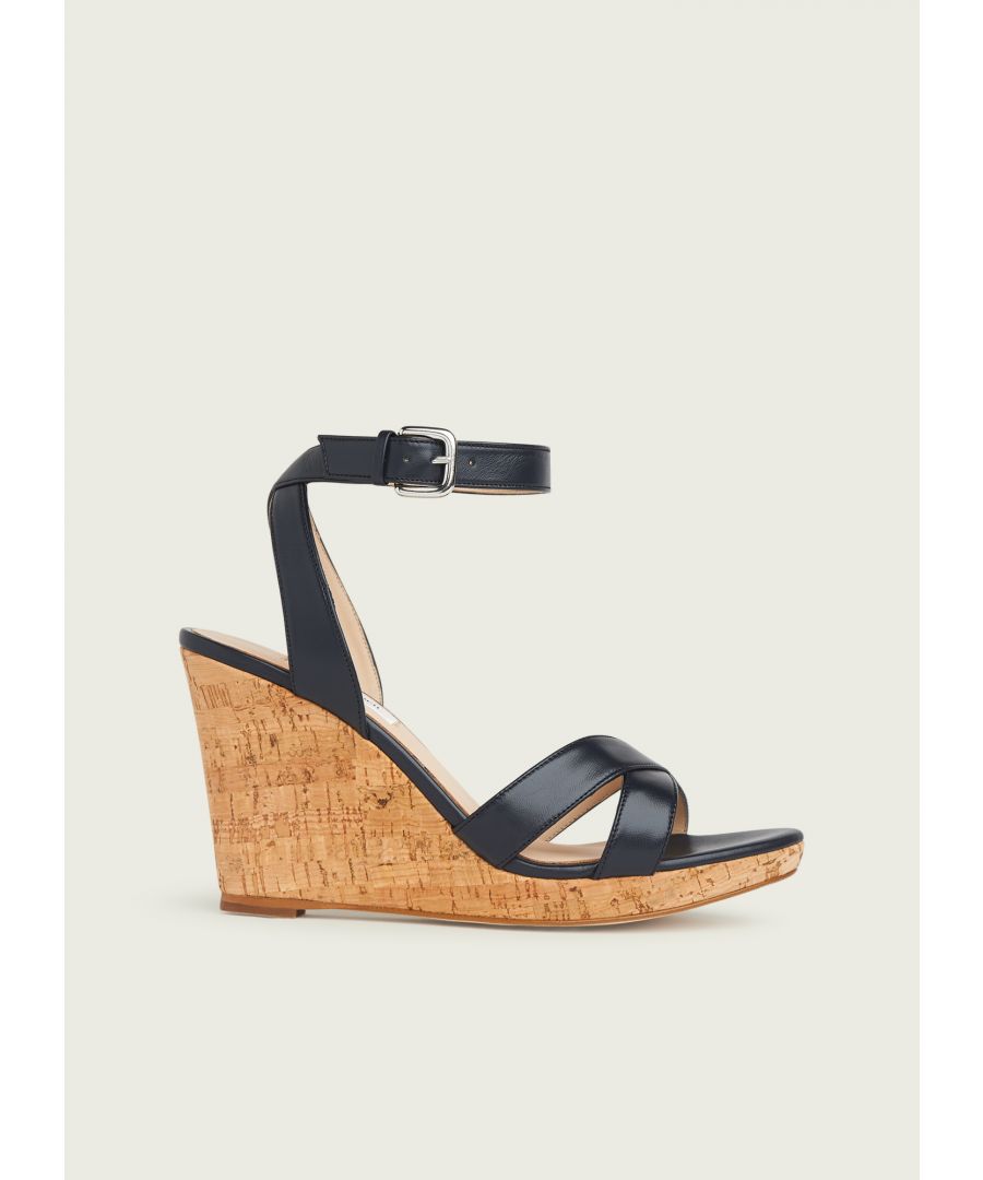 The Overana sandals are crafted in Spain from timeless navy leather. They have crossover straps across the toes, ankle straps with a buckle fastening and a cork wedge heel.