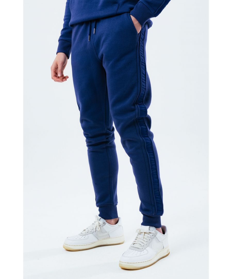 Stay on trend with the Hype Navy Tonal Tape Scribble Logo Men's Joggers and grab the matching hoodie to complete the set. Designed in a soft-touch 70% Cotton 30% Polyester fabric base with the supreme amount of comfort you need from your new joggers. The design boasts an acid wash or tie-dye wash finish with an elasticated waistband, drawstring pullers and fitted cuffs. Machine wash at 30 degrees.